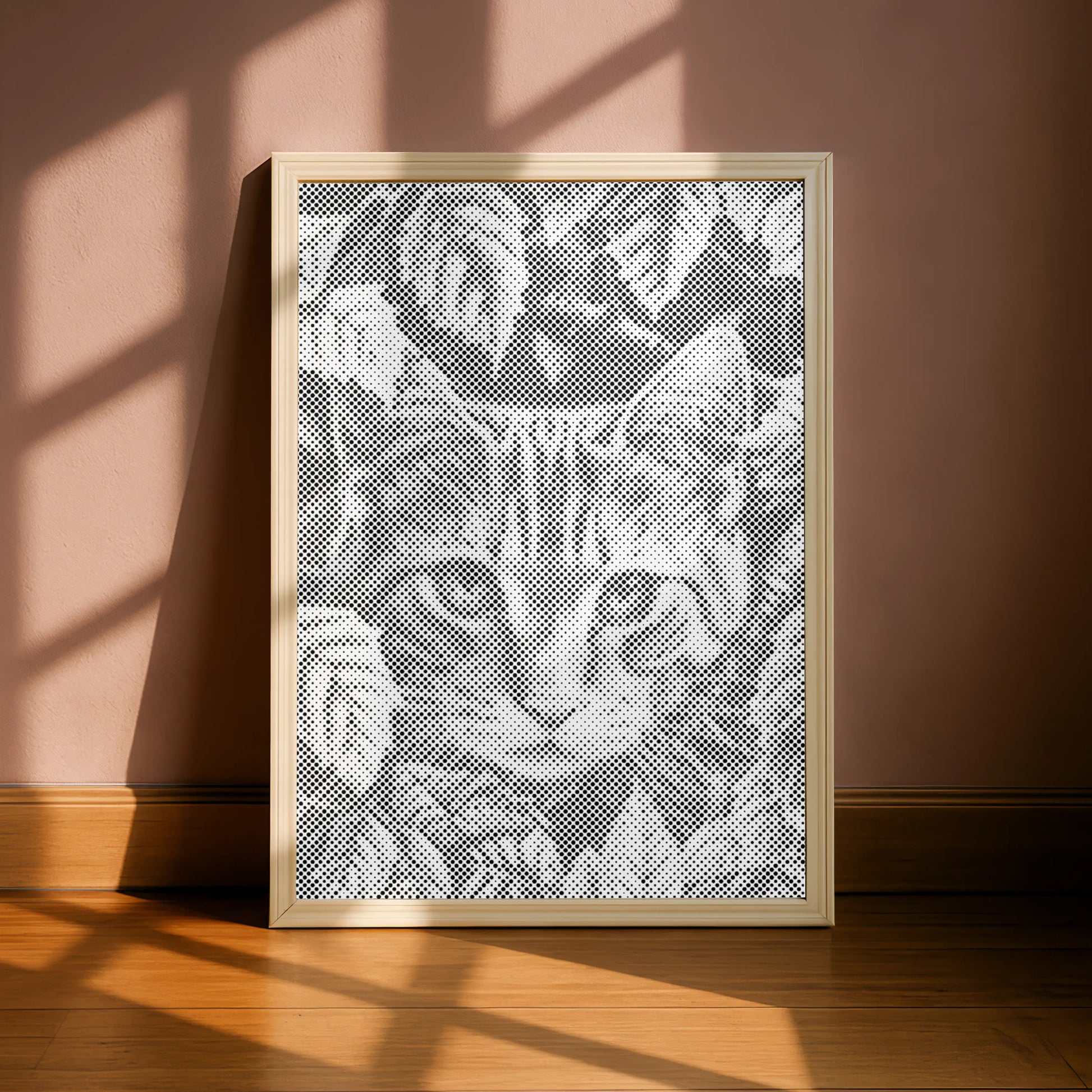 Framed lace art of a cat's face on a pink wall with sunlight casting shadows.