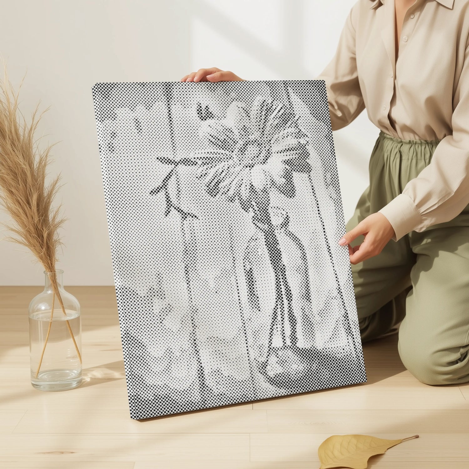 Person holding a black and white abstract art piece on a wooden floor with a vase and leaves in the background. Floral Dot Painting Kits