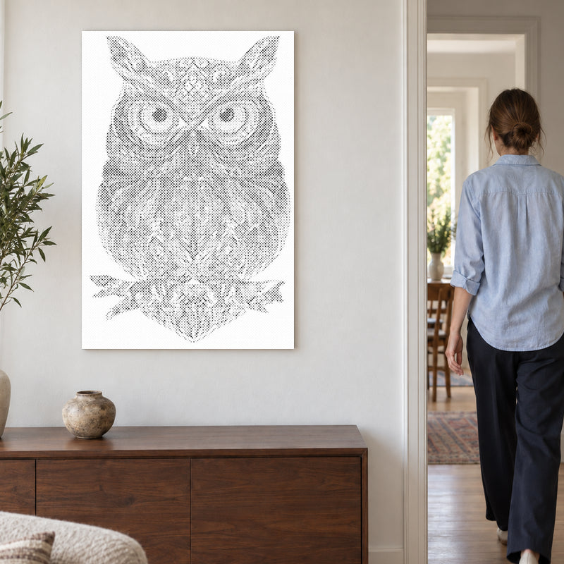 Dot-painting canvas “Owl Mandala”, on a light wall with a person walking through the doorway nearby.